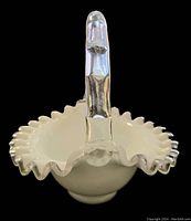 Front angle view of the white milk glass basket showing the ruffled edge and silver crest clear handle