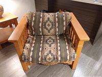 Front view of wood framed chair showcasing patterned cushions and carved arm details.