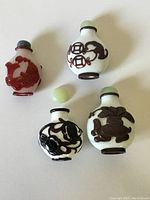 Top view showing four snuff bottles with two jade stoppers, one lapis stopper, and one missing internal stick.