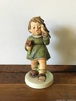 Front view of 'Joyful Adventure' Hummel figurine depicting a child holding a flower and bird.