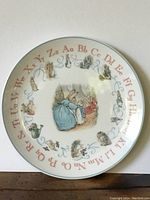 Top view of the Peter Rabbit Wedgwood alphabet plate showing colorful alphabet letters and illustrations around the edge and a central character image.