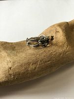 Photo of vintage sterling silver band ring on wooden hand display, showing split shank design with black decorative accents and tarnish.