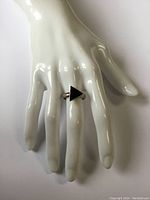 Front view of sterling silver ring with triangular black onyx on finger display.