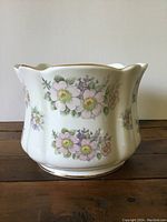 Porcelain flower pot showing floral decoration around the exterior surface