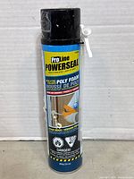 Front view of a ProLine Powerseal poly foam spray can with black cap and nozzle trigger, showing the brand and product type for insulating doors and windows.