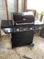 Frontal view of entire grill showing body, lid, control panel, left side shelf and wheels
