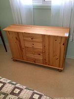 Front view of the solid pine cabinet showing the four drawers in the middle and single doors on each side.