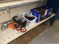 Shelf view showing assortment of clamps and small vise along with boxed sprayer