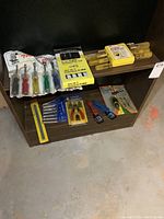 Photo showing nut driver set with color-coded handles, multiple yellow-handled punch and driver sets in plastic cases, snap ring pliers, small pliers, and tool sets on bottom two shelves.
