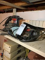 Two Craftsman power tools: an electric belt sander and an electric planer on a shelf.