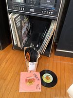 Vintage LP records vertically arranged on shelf with visible album 'The Best of Steve and Eydie'. Adjacent box of 45 RPM singles visible beneath with some 45s displayed at the front.