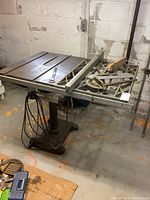 Full view of the vintage Craftsman 100 table saw with cast iron top and base, showing the rip fence and blade slot on the table surface.