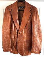 Front view of vintage Saint Arnaud leather jacket showing notch lapel, three patch pockets, and single front button closure.