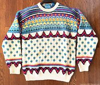 Front view of vintage Britches hand knit wool sweater showing colorful geometric and floral pattern, ribbed crew neck, cuffs, and hem.