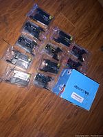 Overview photo of all ink cartridges in original packaging, assorted colors including black, yellow, cyan, and magenta, placed on wooden floor.