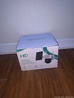 Photo of the closed box labeled 'HD Intelligent Solar Energy Alert PTZ Camera' with image of camera and solar panel on packaging.