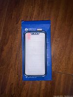 Black protective case positioned on top of blue Oretech packaging box, showing front side of case with precise cutouts.