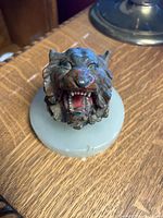 Top view of cast iron lion head inkwell closed on stone base