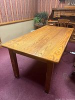 View of the oak conference table top and legs showing wood grain and finish.