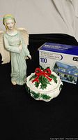 Ceramic angel figurine next to Japanese bowl and boxed icicle lights