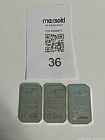 Overview of three Johnson Matthey silver bars with auction lot sign