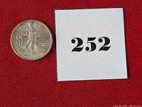 Silver round front side showing Walking Liberty design and seller lot number card.