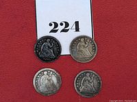 Four half dimes arranged on a red background displaying front obverse side with Lady Liberty seated, dated 1840, 1845 (two coins), and 1856.