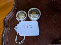 Two metal buttons in small clear cases, one labeled 'Civil War Cavalry Button' and the other with a crest design.