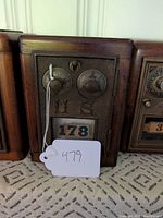 Front view of the oak locking box showing the vintage US post office mailbox metal door with combination dials and number 178.