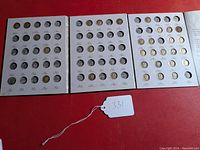 Full view of open three-part Mercury dime album showing slots with some coins and many empty slots.