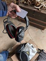 Photo showing the full pair of black Patriot waterproof headphones with visible wear and attached coiled cable.