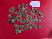 Lot of Indian Head cents spread on red surface