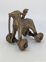 Side angle showing ornamental brass elephant and rider on four wheels with iron axles