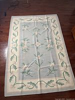 Full view of the rectangular handmade rug showing the central blue field and floral motifs with border design.