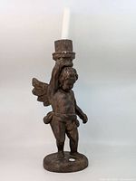 Front view of full cherub candleholder with white taper candle