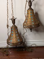 Pair of two pendants on floor showing entire fixtures with chains and cords