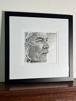 Full view of framed portrait resting on a wooden surface