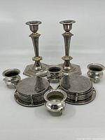 Full set showing candlestick holders, coasters in racks, and cauldrons