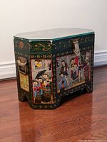 Oblique front view of the octagonal painted chest showing detailed colorful scenes of court musicians and ornate floral borders.