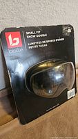 Photo of Bolle snow goggles sealed in original black packaging, showing front with small fit and product name.