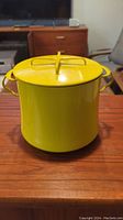Front view of yellow Dansk cast iron pasta pot with lid, showing full pot and two side handles.
