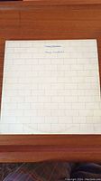 Front cover of Pink Floyd The Wall vinyl album showing white brick wall design with handwritten text