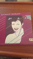 Front cover of Duran Duran 'Rio' vinyl record album showing stylized illustration of woman's face and album title.