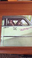 Front cover of Los Cochinos vinyl LP showing Cheech and Chong in a car.