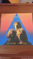Front cover of The Police's "Zenyatta Mondatta" vinyl record featuring the three band members against a colorful triangular background.