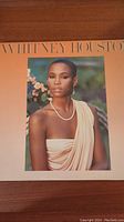 Front cover of Whitney Houston vinyl record album showing a photographic portrait of Whitney in a draped beige dress.