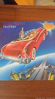 Front cover of the vinyl album 'Don't Fight It' by Red Rider showing a red convertible flying over a cityscape.