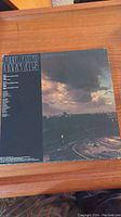 Back cover of Pink Floyd "Animals" album showing tracklist and credits with an urban landscape and cloudy sky.