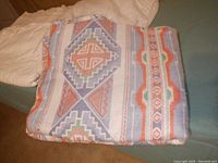 View of southwestern patterned layering blanket folded showing geometric patterns in muted colors