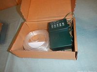 Open box showing clear tube light strand coiled alongside battery pack and control unit.